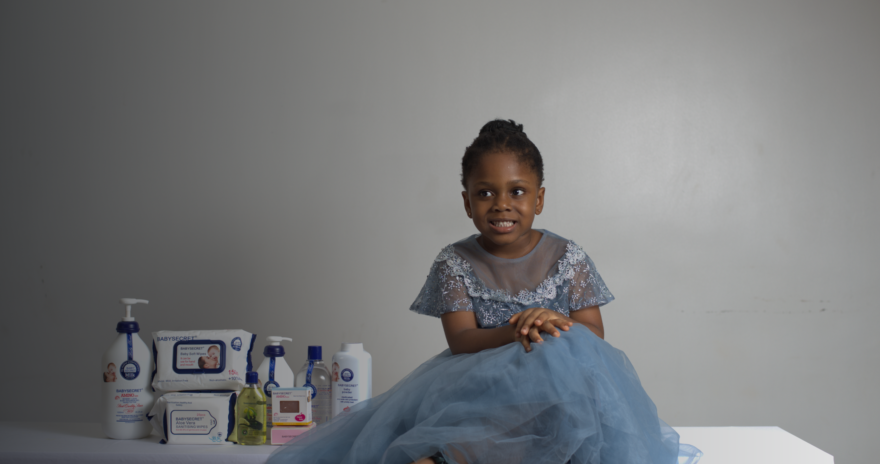 A child surrounded by Baby Secret products